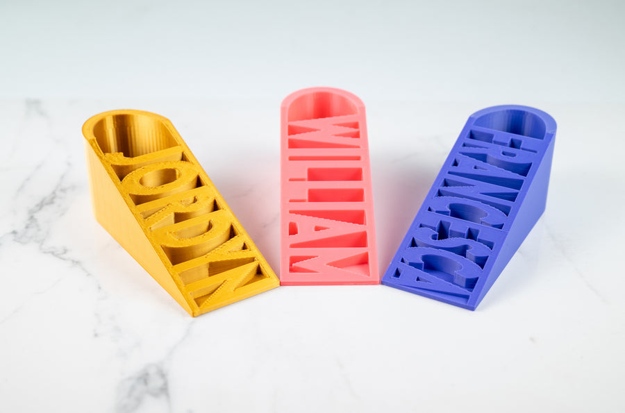 Colourful personalised wedge door stops with names built into the design